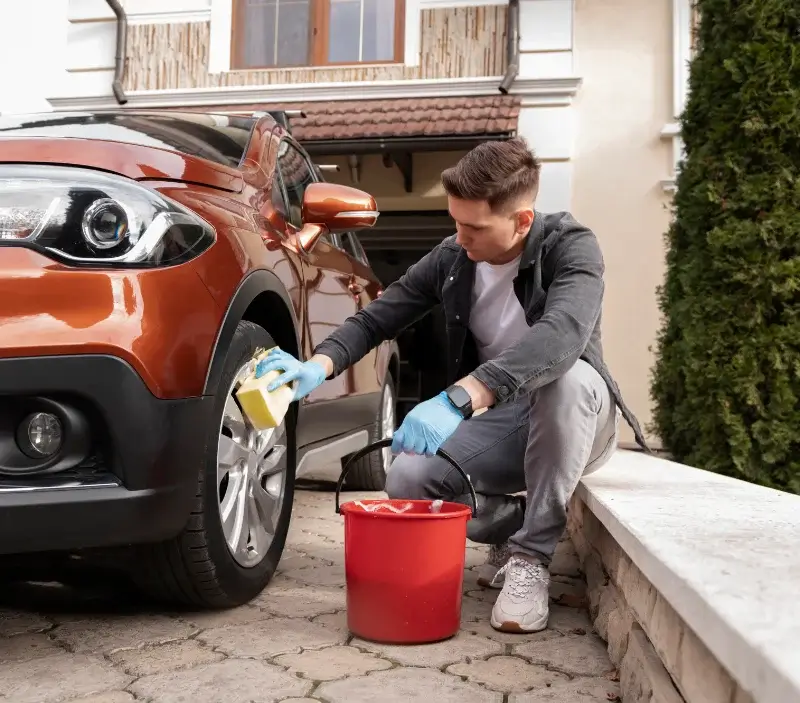 Lavage auto à domicile Les Monts d'Andaine : professionnel intervenant sur un véhicule